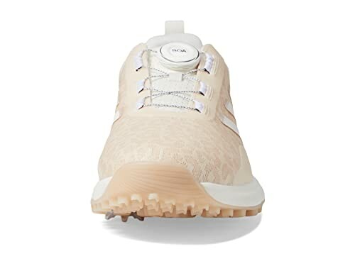 Front view of a beige sneaker with a unique lacing system.