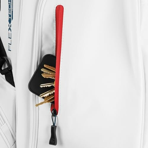 Golf bag pocket holding keys and a black case.