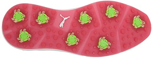 Golf shoe sole with green spikes on pink background.