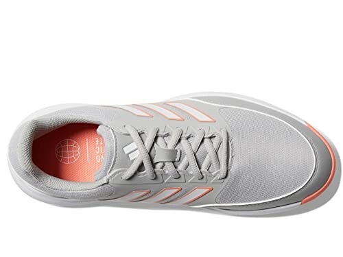 Top view of a gray sneaker with orange accents and white stripes.