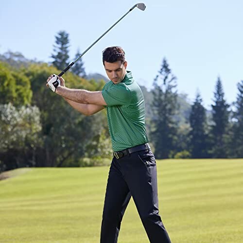 Man in green shirt playing golf on a course.