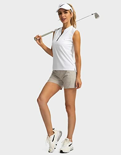 Woman in golf attire holding a club.